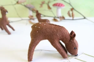 Handmade little felt grazing doe